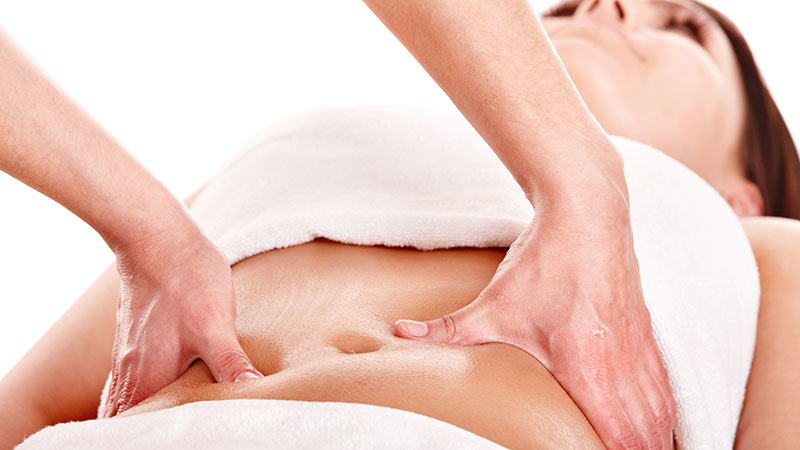 mãos realizando shiatsu no tronco de uma mulher