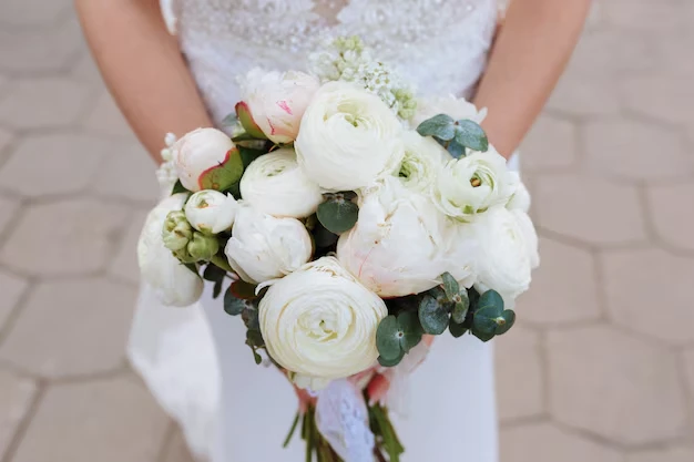 Imagem de um buquê de casamento com flores brancas e verdejantes, perfeito para celebrações de casamento ou eventos matrimoniais ao ar livre.
