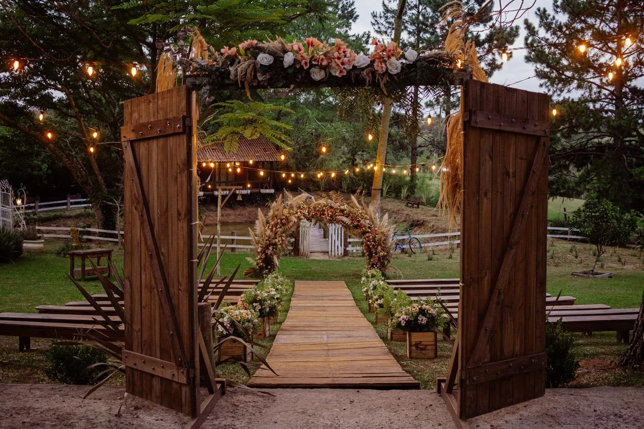 Caminho decorado com flores e luzes, prepare-se para um casamento ao ar livre com uma atmosfera acolhedora e romântica