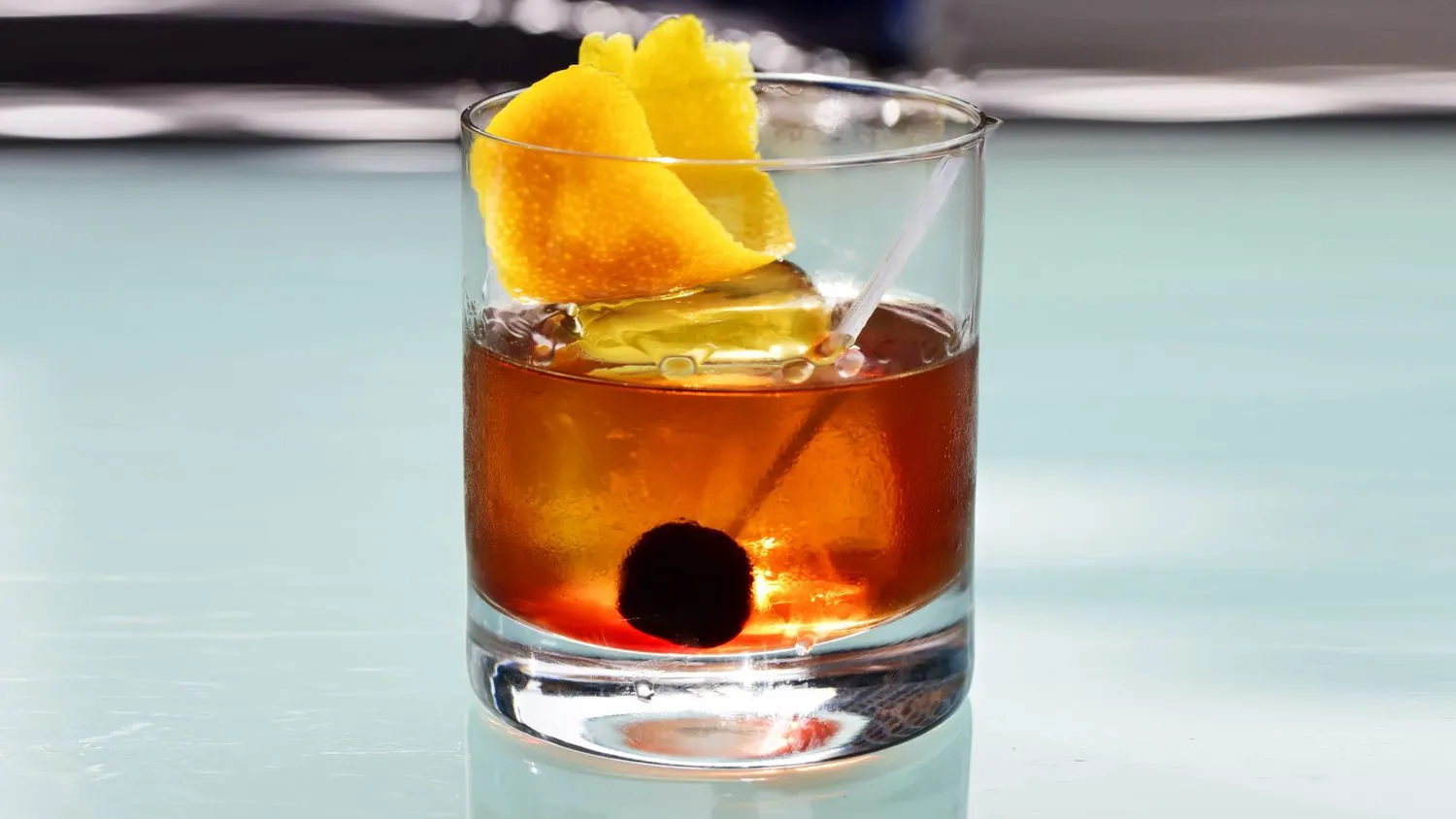 Drink alcoólico com frutas, gelo e uma cereja ao fundo, servido em copo de vidro transparente, ideal para festas e celebrações.
