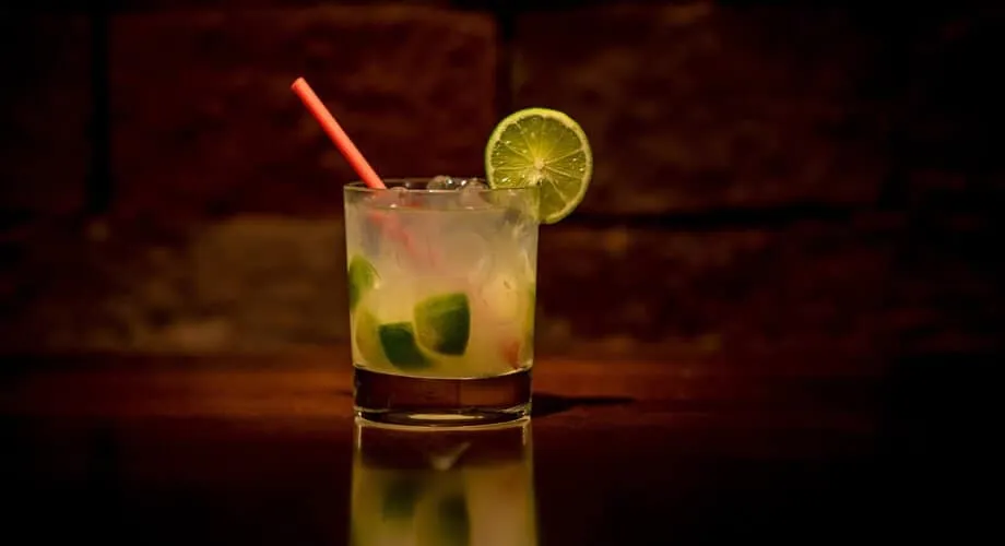Imagem de um drinque refrescante com limão e hortelã em copo de vidro, ideal para aproveitar momentos de descontração e socialização.