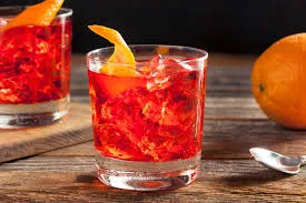 Imagem de um drinque com gelo e uma fatia de limão em um copo de vidro, ambientada sob iluminação suave, ideal para apreciadores de coquetéis sofisticados.