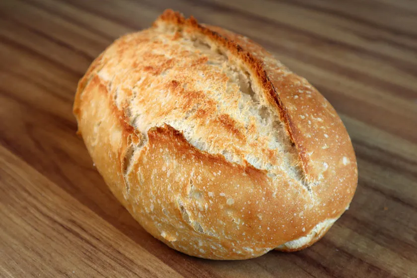 Pão caseiro fresco com crosta dourada e interior macio, ideal para café da manhã, lanche ou uma refeição reconfortante