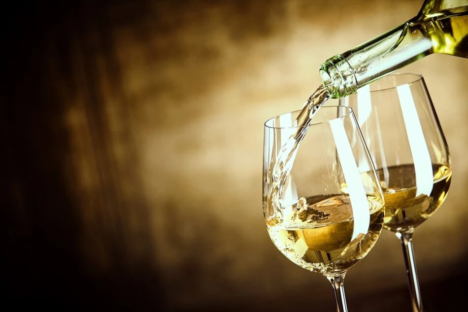 Vinho sendo servido em duas taças de vidro, com uma garrafa despejando a bebida, ideal para apreciar momentos especiais.