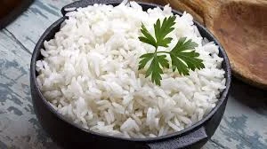 Prato de arroz branco bem cozido com um ramo de salsa decorativa, perfeito para acompanhar pratos típicos brasileiros. Ideal para quem busca refeições práticas e saborosas.