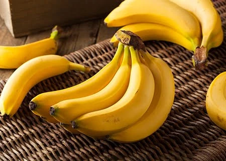 Imagem de várias bananas maduras em uma cesta de fibra natural, ideal para consumo e dar energia como uma fruta saudável.