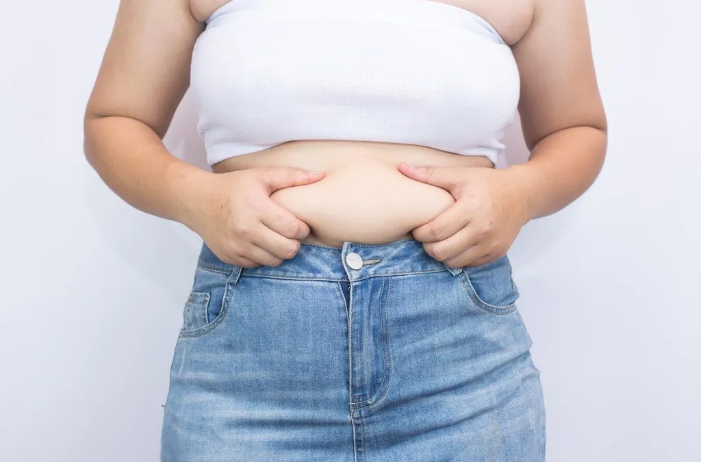 imagem de mulher segurando a gordura da barriga