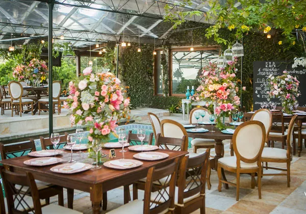 Mesa de jantar elegante decorada com arranjos de flores na primavera, pronta para um almoço ou jantar especial ao ar livre.