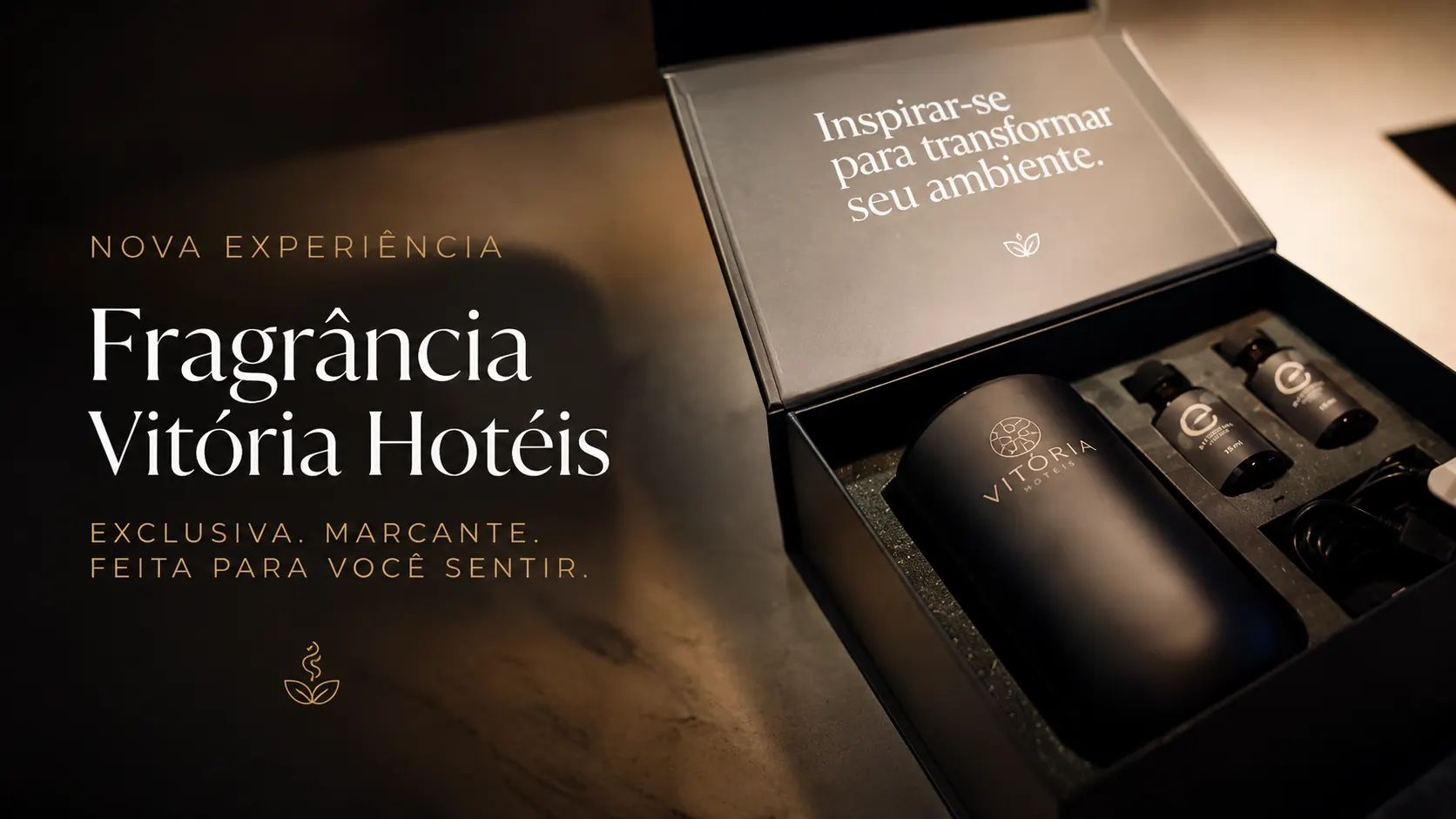 Imagem promocional com caixa e frascos de fragrância “Vitória Hotéis”, com texto “Nova experiência” e legenda “Inspirar-se para transformar seu ambiente”, destacando um vídeo com ícone de play.