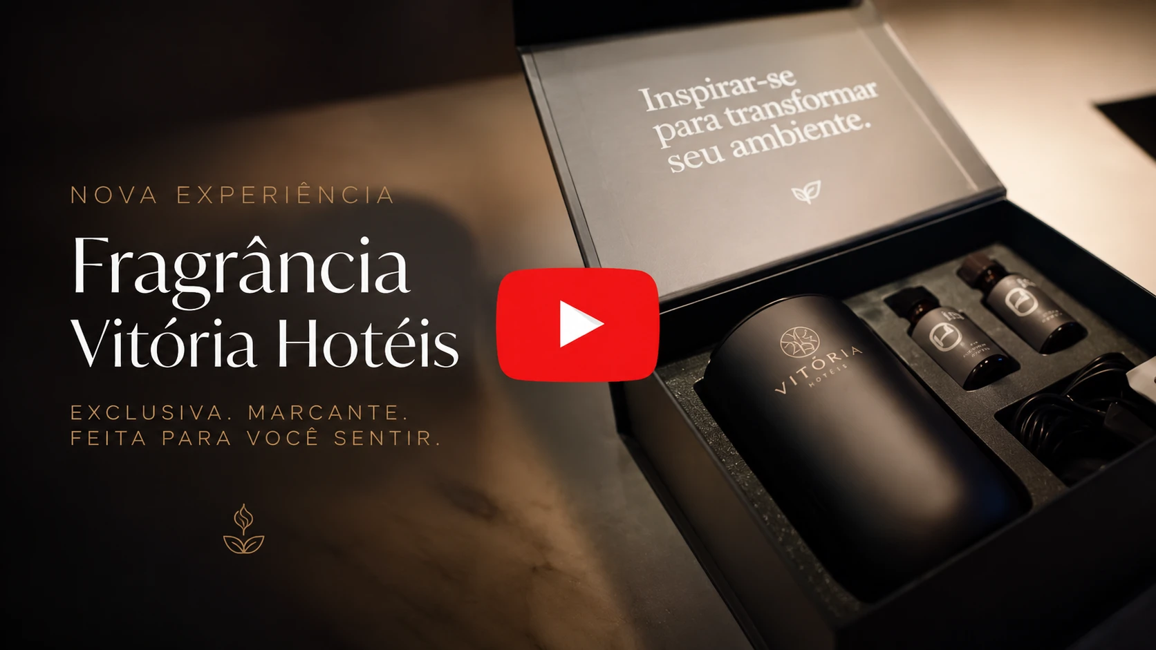 Imagem promocional com caixa e frascos de fragrância “Vitória Hotéis”, com texto “Nova experiência” e legenda “Inspirar-se para transformar seu ambiente”, destacando um vídeo com ícone de play.