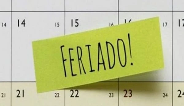 Cartaz verde com a frase “FERTADO!” sobre um calendário, indicando uma data ou lembrete importante.